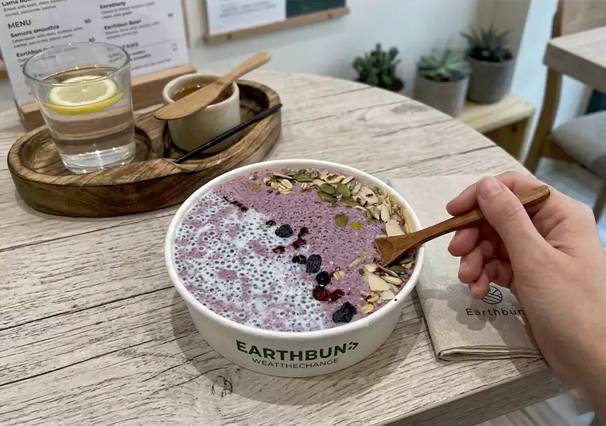 Berry smoothie bowl topped with mixed seeds, nuts, and dried berries.