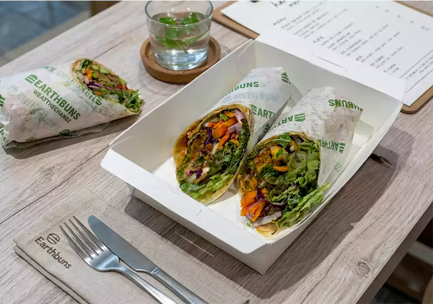 Two vegetable wraps cut in half with fresh greens, shredded vegetables, and colourful fillings.
