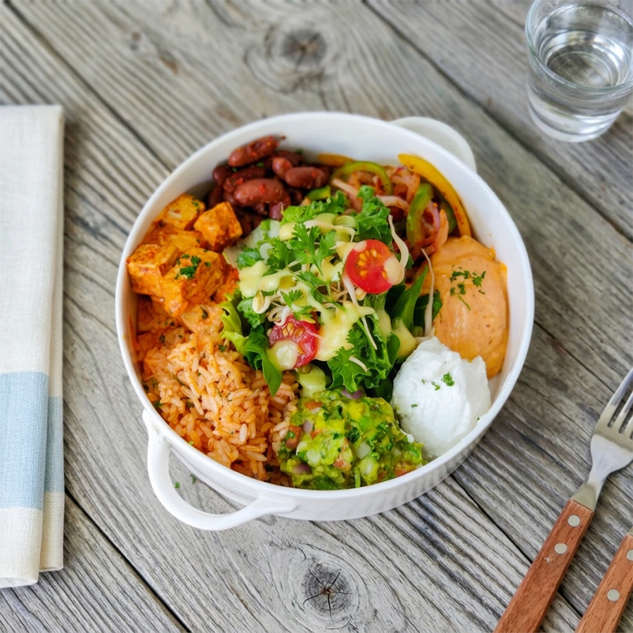 Nutrient-rich burrito bowl featuring brown rice, seasoned tofu, beans, and fresh greens.