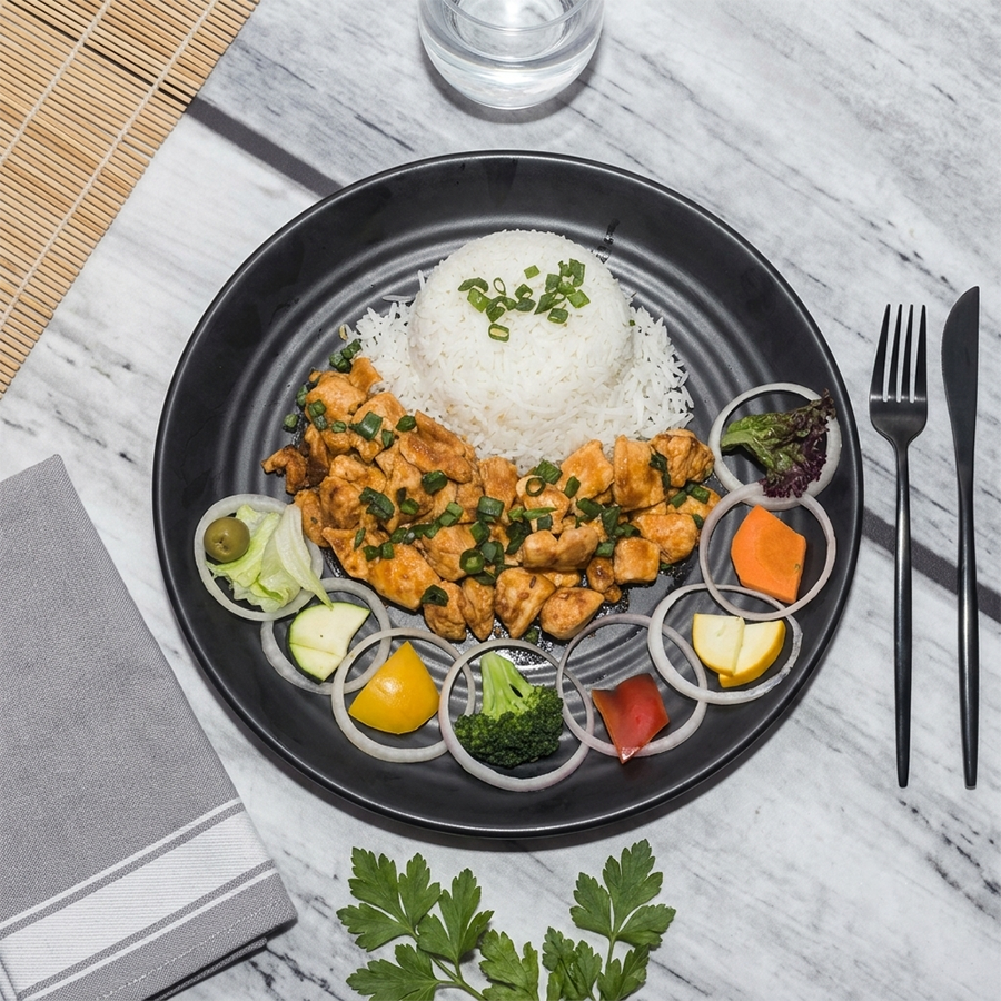 Savory chicken stir-fry with steamed rice, green onions, and fresh vegetable crudités.
