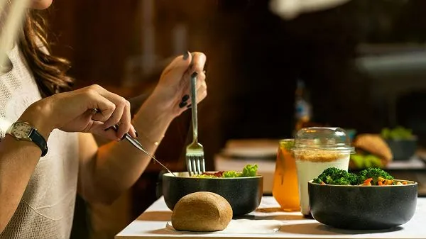Woman eating a balanced whole-food meal while practicing clean eating habits